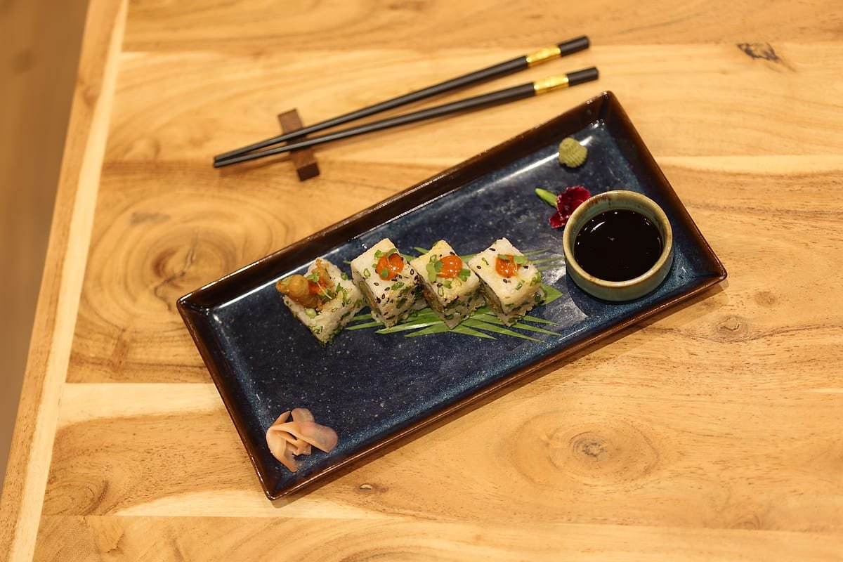Maki and chopsticks photographed from above on pale wood